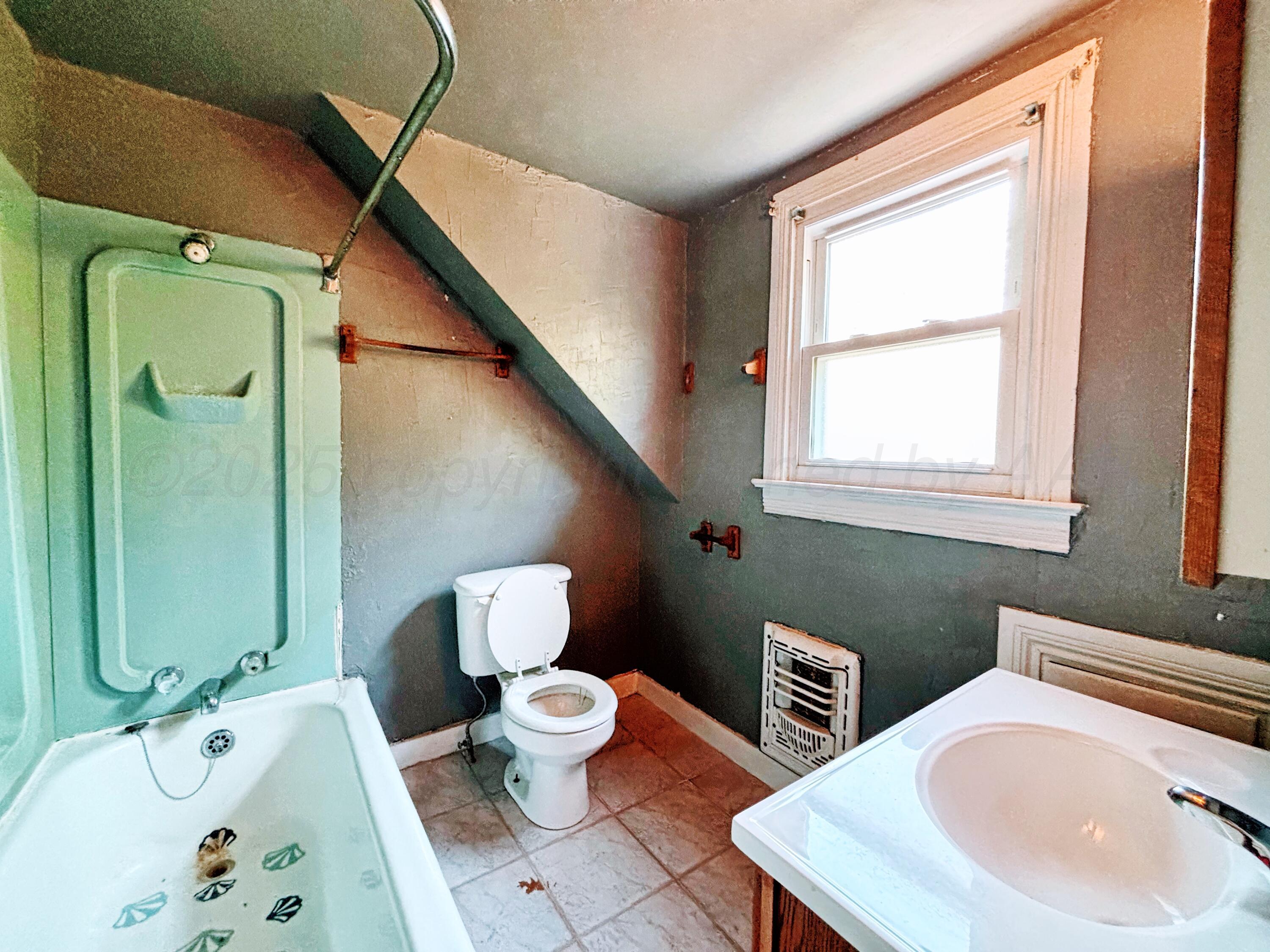 522 South Baylor Street Perryton, TX 79070 - Photo 31 of 52 a bathroom with a sink mirror and toilet