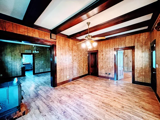 a view of a hallway with wooden floor and a glass door