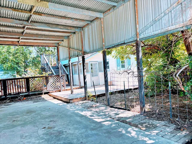 a view of balcony with small potted plants and wooden fence