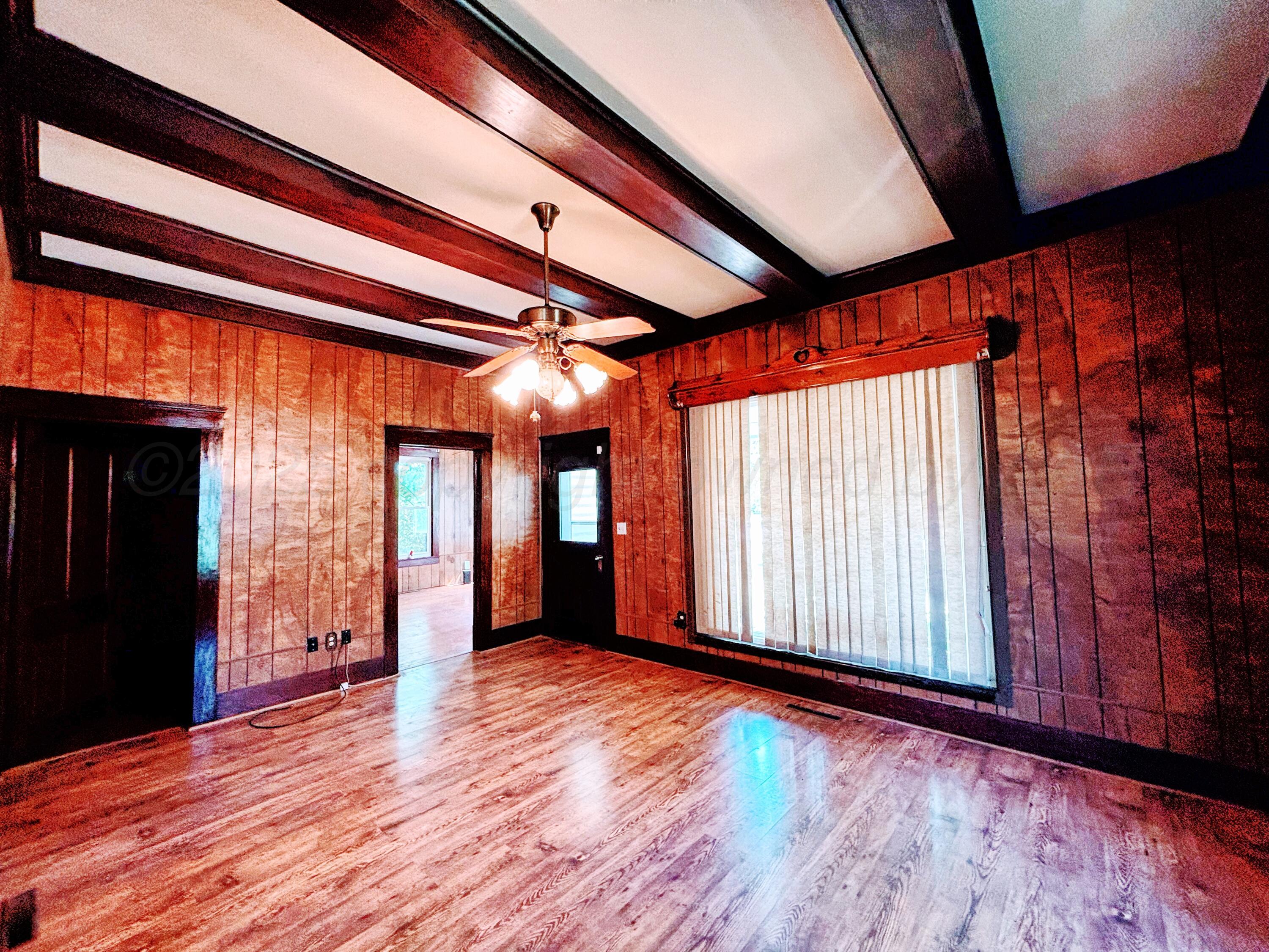 522 South Baylor Street Perryton, TX 79070 - Photo 6 of 52 an empty room with wooden floor and windows