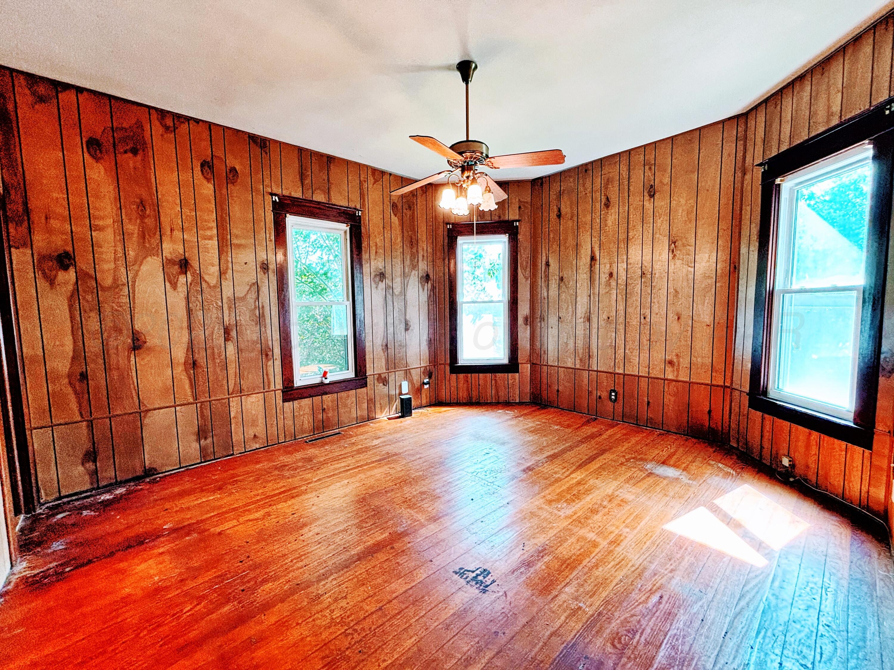 522 South Baylor Street Perryton, TX 79070 - Photo 7 of 52 an empty room with wooden floor and windows