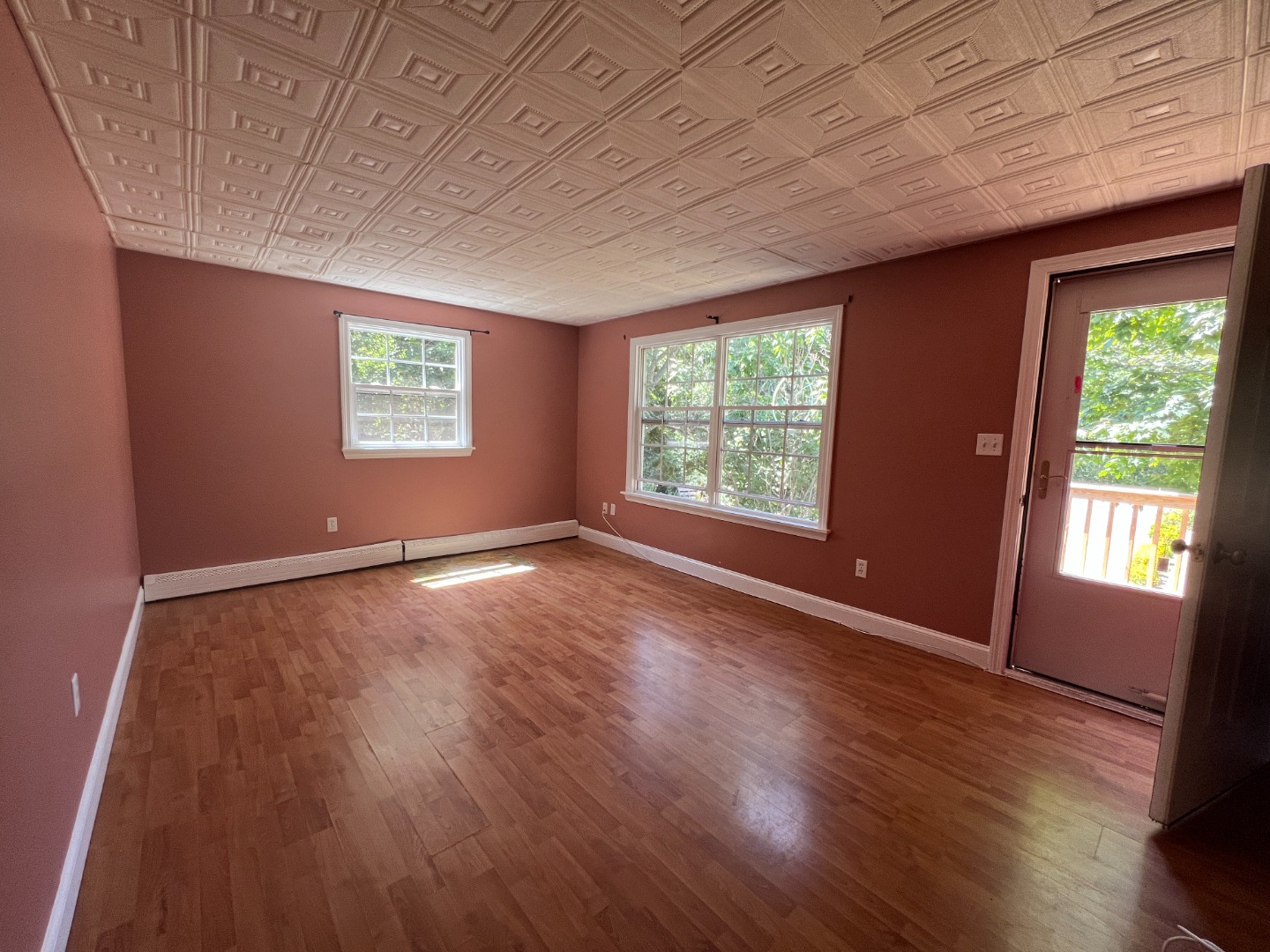 67 12th Street Edgartown, MA 02539 - Photo 4 of 23 an empty room with wooden floor and windows