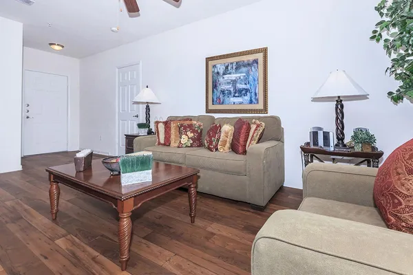 a living room with furniture and a wooden floor