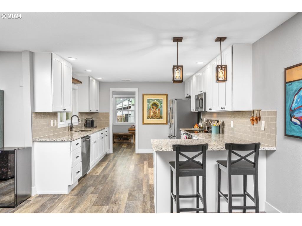 17762 South Redland Road Oregon City, OR 97045 - Photo 9 of 37 a kitchen with stainless steel appliances kitchen island granite countertop a dining table chairs and white cabinets