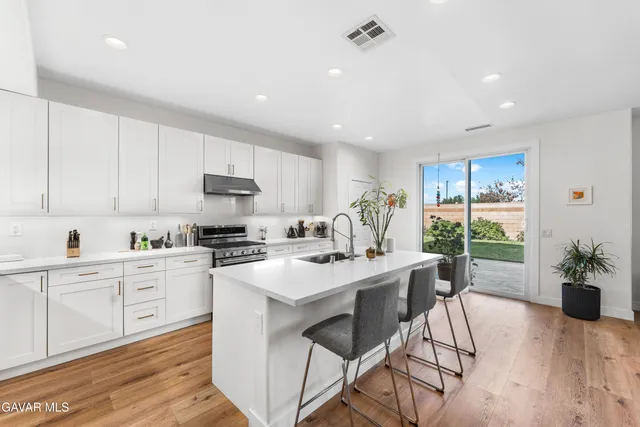 a kitchen with a table chairs sink and cabinets
