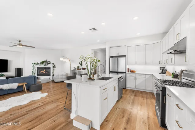 a kitchen that has a lot of cabinets in it and wooden floors