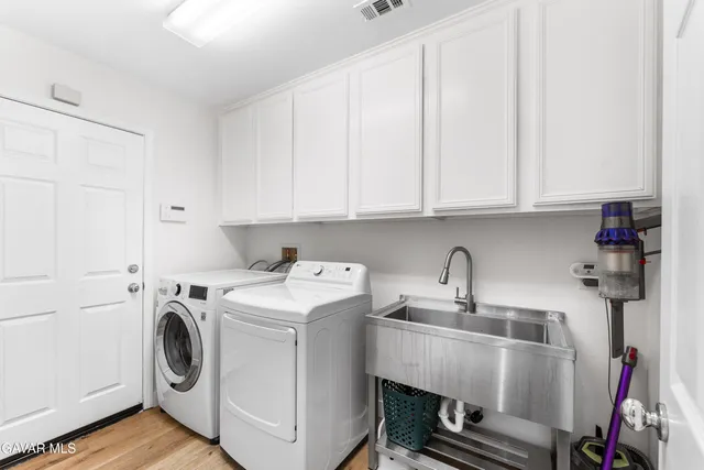 a utility room with sink dryer and washer