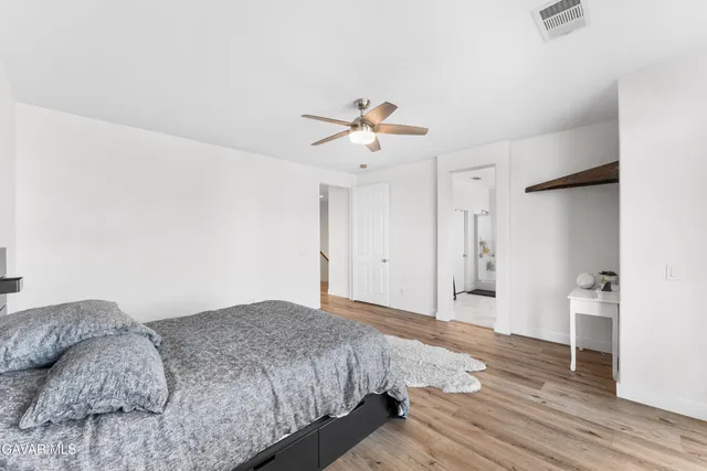 a bedroom with a bed chandelier and a window