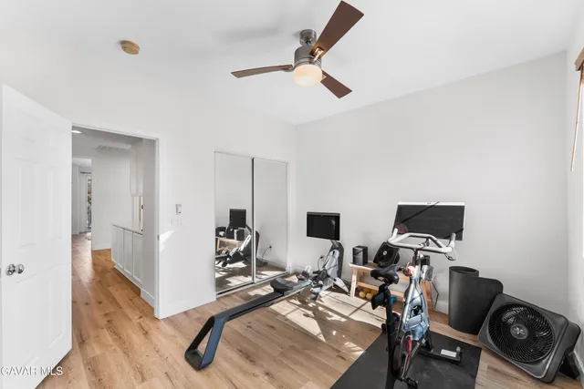 a view of a workspace with furniture and a ceiling fan