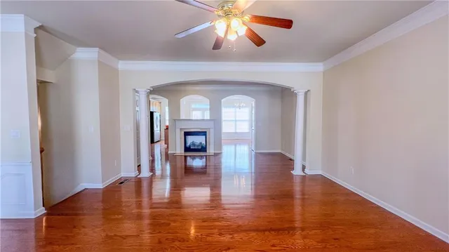 a view of a livingroom with wooden floor and a ceiling fan