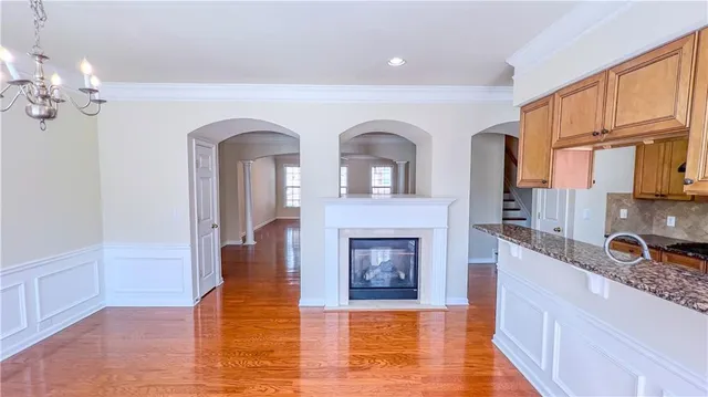 a large kitchen with stainless steel appliances granite countertop a stove cabinets and wooden floor