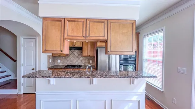 a bathroom with a granite countertop sink and a window