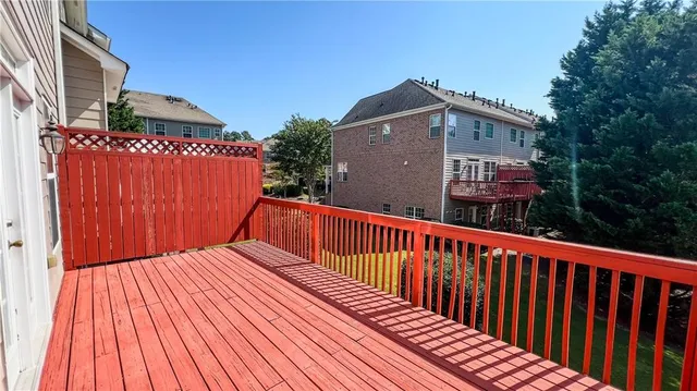 a view of a brick building with a yard plants and large tree