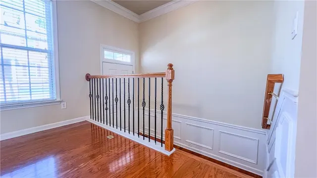 a view of a hallway with wooden floor and a window