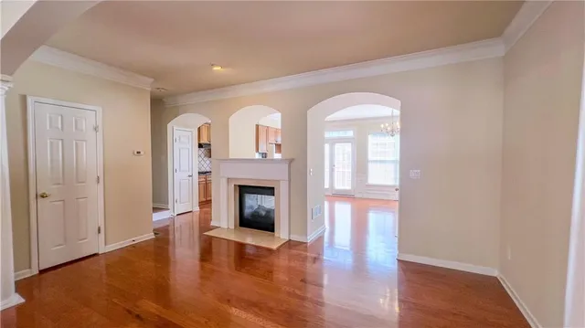 a view of empty room with fireplace and wooden floor