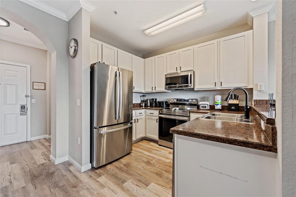 14200 Avalon Road, Unit 409 Winter Garden, FL 34787 - Photo 13 of 33 a kitchen with granite countertop a refrigerator stove and microwave