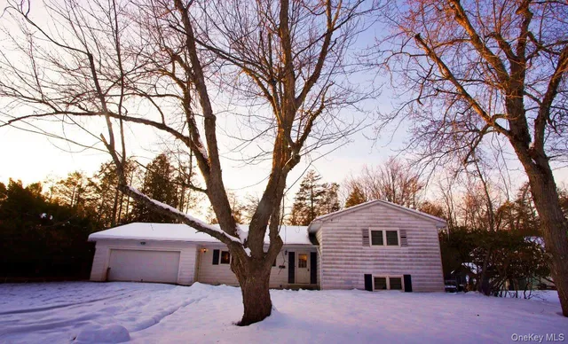 a front view of a house with a garden and trees
