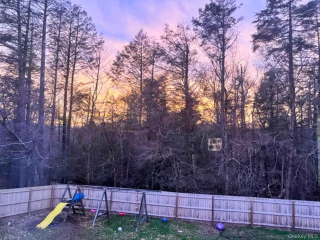 a front view of a house with a yard and tree