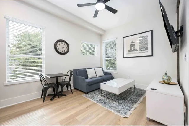 a living room with furniture a flat screen tv and a window