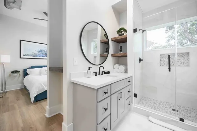 a bathroom with a double vanity sink mirror and shower