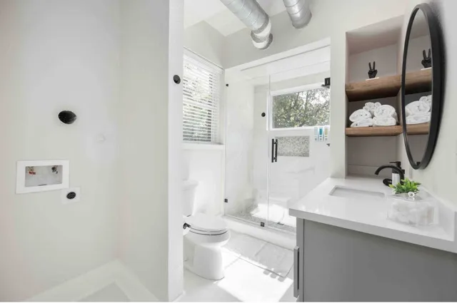 a bathroom with a sink a toilet and mirror