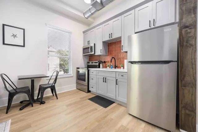 a kitchen with cabinets a refrigerator and a stove top oven