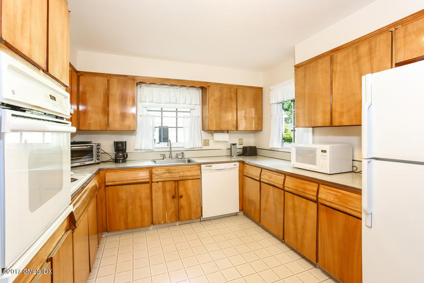 26 Spring Street Riverside, CT 06878 - Photo 8 of 25 a kitchen with stainless steel appliances granite countertop a refrigerator sink and white cabinets