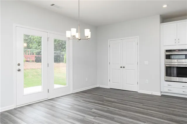 a view of empty room with wooden floor and window