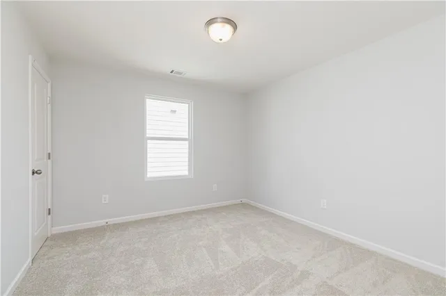 an empty room with wooden floor and a bathroom