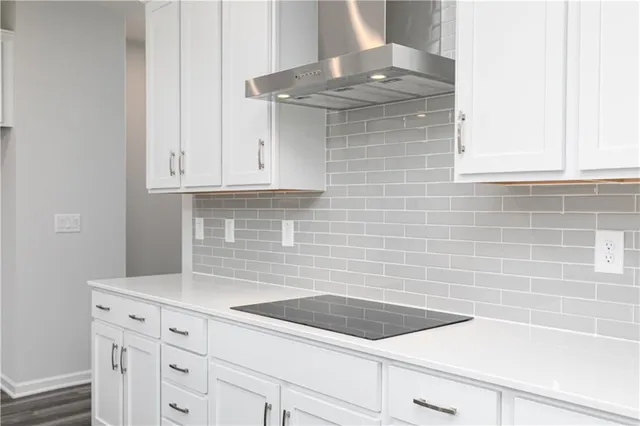 a kitchen with granite countertop white cabinets and a stainless steel appliances