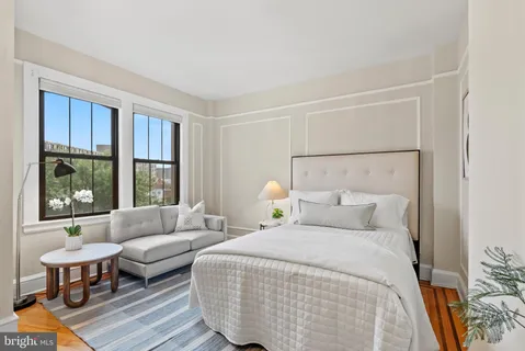 a bedroom with a bed a large window and couch