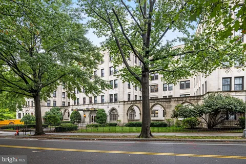 a front view of a house with a garden and trees