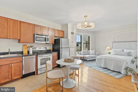 a kitchen with stainless steel appliances granite countertop a refrigerator a stove a sink dishwasher and white cabinets with wooden floor