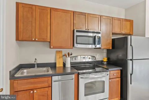 a kitchen with a sink a stove a microwave and cabinets