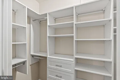 a view of walk in closet with empty racks