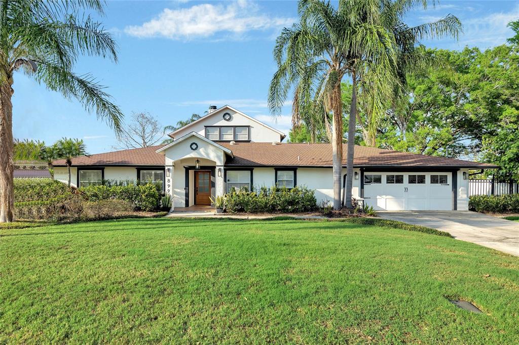 899 West Lake Holden Point Orlando, FL 32805 - Photo 1 of 52 a front view of a house with a garden and trees