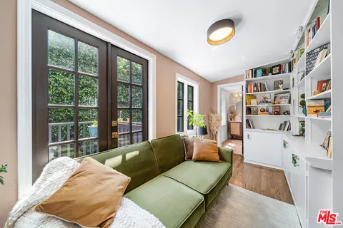 a dining room with furniture potted plants and wooden floor