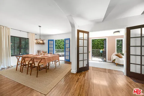 a dining room with furniture a chandelier and wooden floor