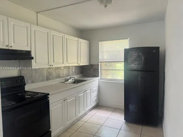 a kitchen with a refrigerator stove and cabinets