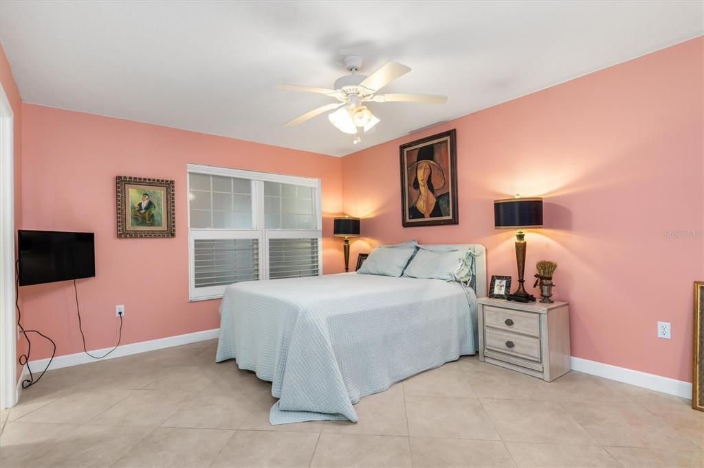 1 Colony Point Drive, Unit A8 Punta Gorda, FL 33950 - Photo 27 of 62 a bedroom with a bed and a flat tv screen on dresser