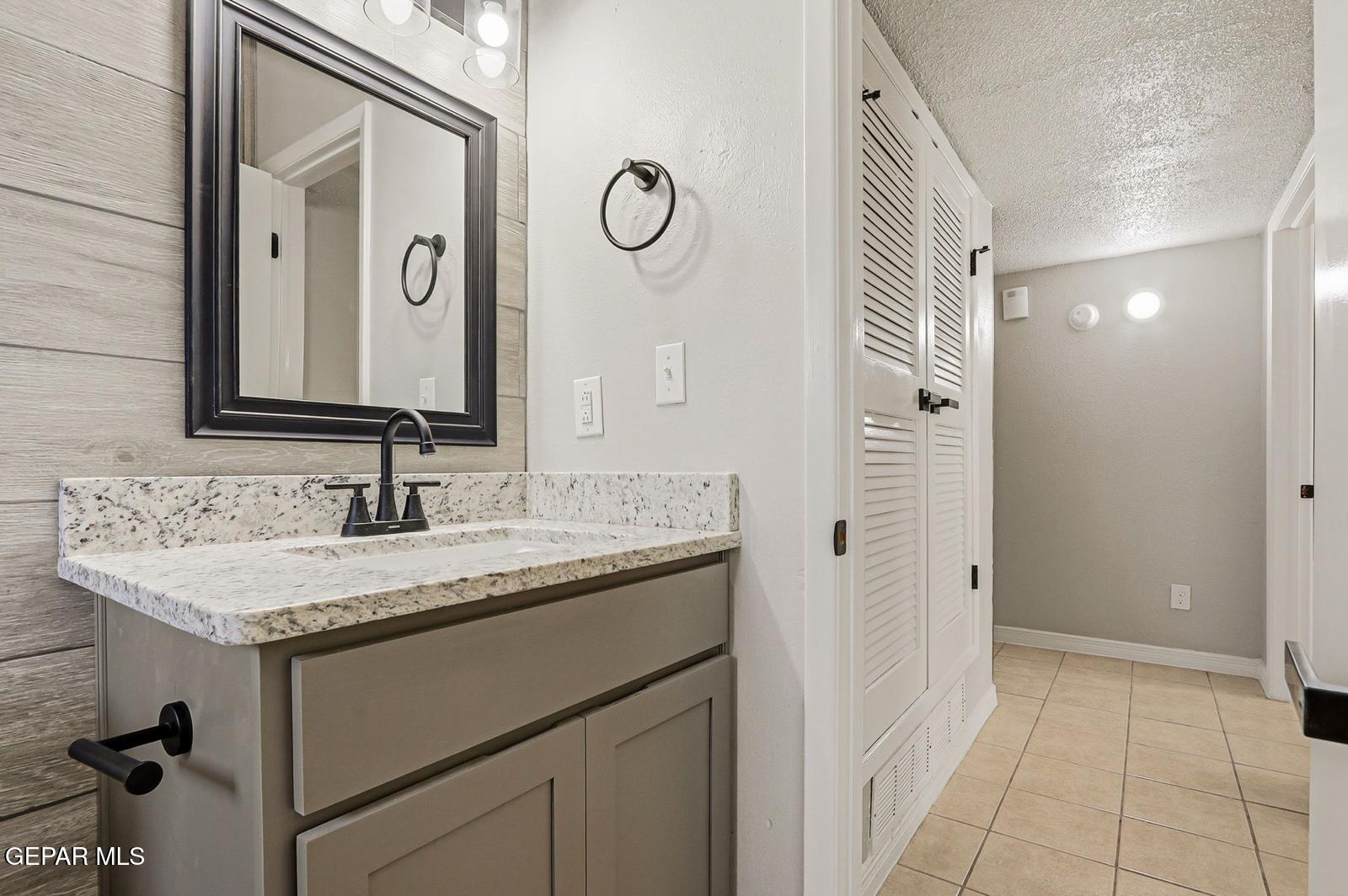 366 Riverside Drive Sunland Park, NM 88063 - Photo 29 of 34 a bathroom with a granite countertop sink and a mirror