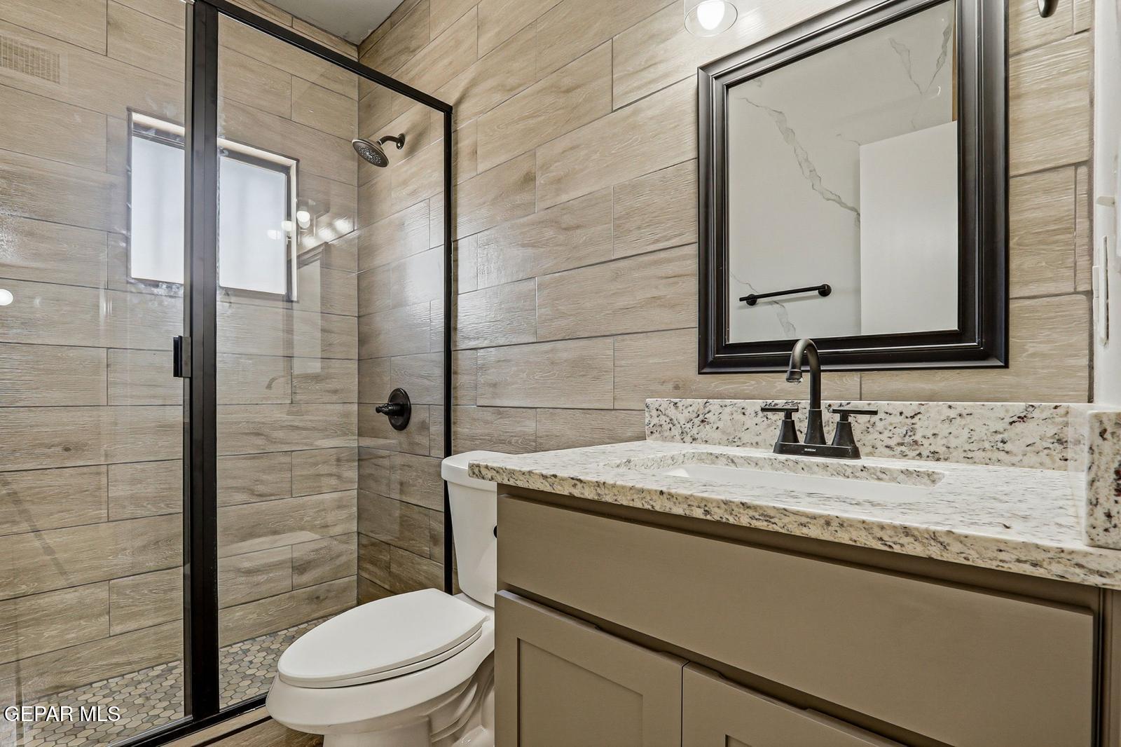 366 Riverside Drive Sunland Park, NM 88063 - Photo 7 of 34 a bathroom with a granite countertop sink toilet a mirror and shower