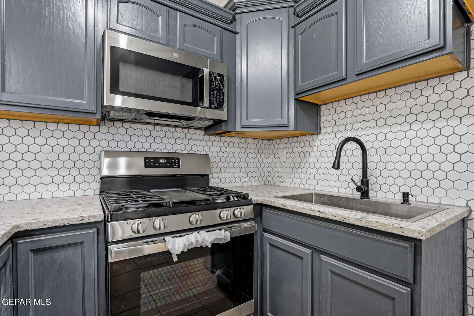 366 Riverside Drive Sunland Park, NM 88063 - Photo 10 of 34 a kitchen with stainless steel appliances granite countertop a stove and a microwave