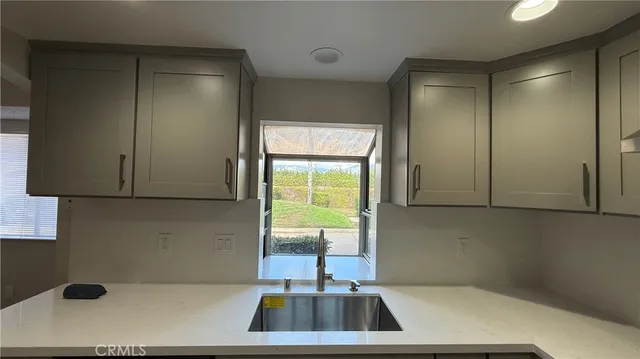 a view of a hallway with wooden floor and a sink