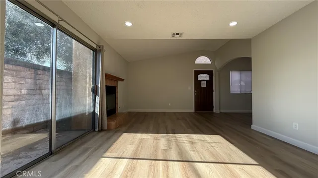 a view of room with wooden floor and flat screen tv