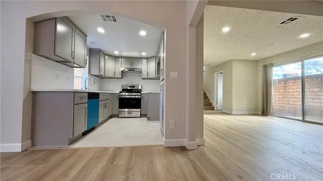 a kitchen with granite countertop a stove a sink and a refrigerator