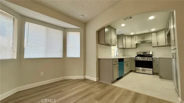 a kitchen with stainless steel appliances a sink stove and refrigerator