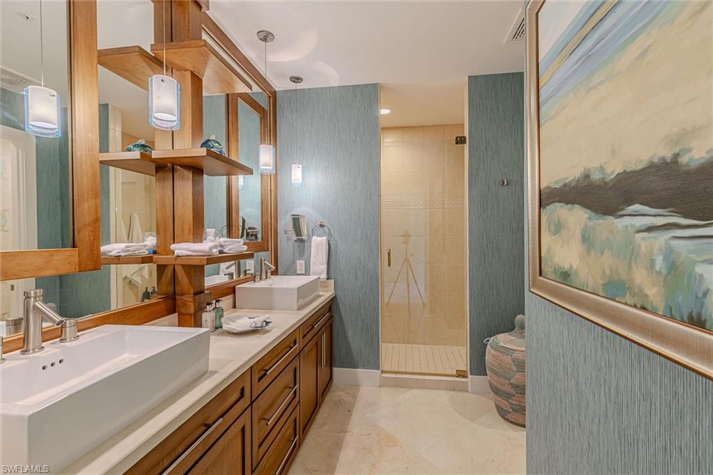 295 Grande Way, Unit PH2 Naples, FL 34110 - Photo 18 of 45 a bathroom with a double vanity sink a mirror and a shower