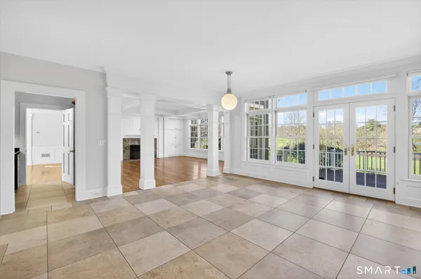 a view of an empty room with wooden floor fireplace and a window
