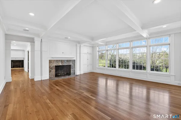 a view of empty room with wooden floor and fireplace